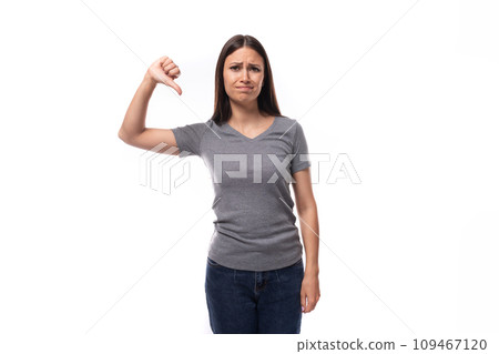 young positive brunette woman demonstrates a t-shirt with space for printing identities on a white young positive brunette woman demonstrates a t-shirt with space for printing identities on a white 109467120