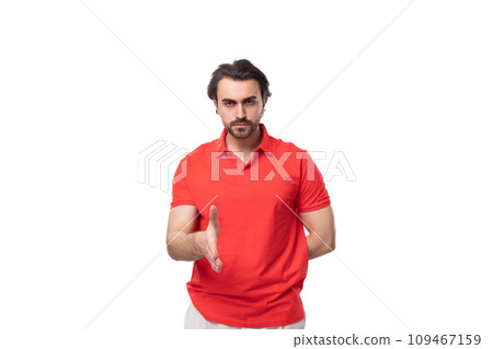 young brunette man with a beard dressed in a red T-shirt gives a hand for a handshake on a white 109467159