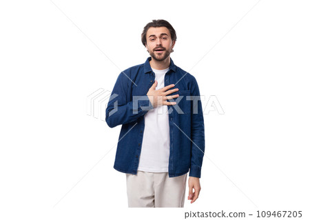 young handsome caucasian man with black hair is dressed in a blue shirt and light trousers on a 109467205