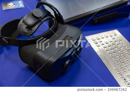 VR headset lays on the desk near industrial built-in keyboard, close up VR headset lays on the desk near industrial built-in keyboard, close up 109467262