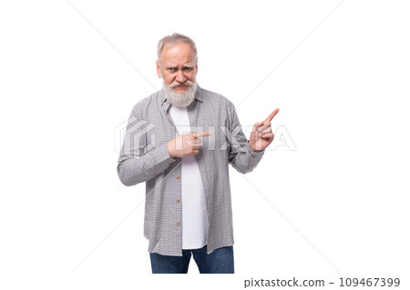 well-groomed senior man with a gray beard and mustache is dressed in a plaid shirt and jeans on a well-groomed senior man with a gray beard and mustache is dressed in a plaid shirt and jeans on a 109467399
