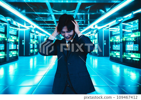 Businessman holding his head in the server room Businessman holding his head in the server room 109467412