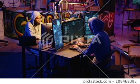 Hackers rushing to leave underground base after hearing police sirens while pirating software. Rogue programmers running to escape law enforcement coming to arrest them for cracking videogames 109468395