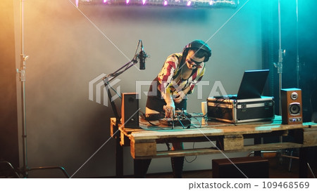 Sleepy dj woman yawning and trying to mix records at party, drinking coffee to get some energy for great techno performance at nightclub. Artist feeling exhausted at stereo turntables. Handheld shot. 109468569