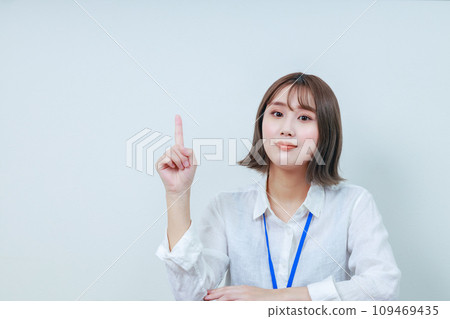 Young woman looking at camera with index finger raised 109469435