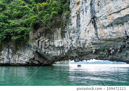 越南:一個人在奇岩怪石環繞的下龍灣劃著獨木舟,到達一個旅遊景點。 越南:一個人在奇岩怪石環繞的下龍灣劃著獨木舟,到達一個旅遊景點。 109472121