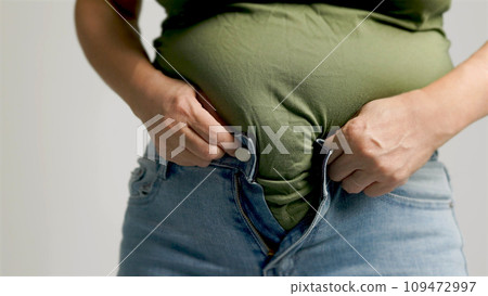 Fat  woman zipping up trousers, excess belly fat, unhealthy lifestyle 109472997
