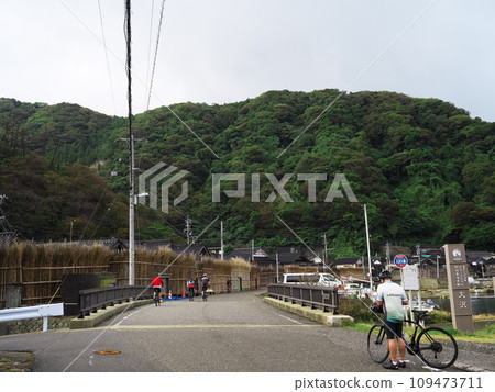 A cyclist walks through the quaint townscape of Osawa-cho, Wajima City, Ishikawa Prefecture. 109473711