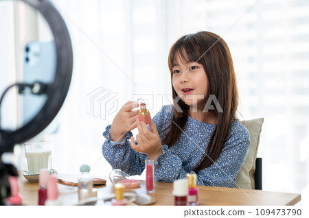 A talented and cute young Asian girl is reviewing her kid cosmetic on her social media. 109473790