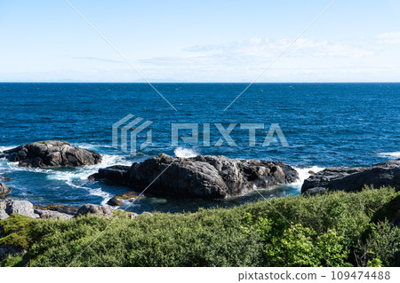 The deep blue Ocean with waves crashing on a rocky island. rugged, rocky coastline at the Sea The deep blue Ocean with waves crashing on a rocky island. rugged, rocky coastline at the Sea 109474488