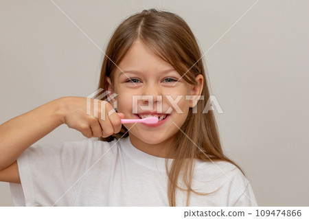 Portrait of caucasian happy little girl with open wide smile holding tooth brush near teeth looking at camera Portrait of caucasian happy little girl with open wide smile holding tooth brush near teeth looking at camera 109474866