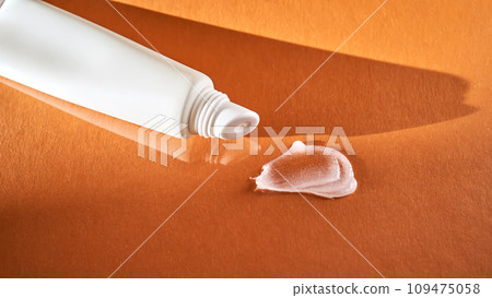 Hygienic moisturizing lip balm in a tube on a orange background. 109475058