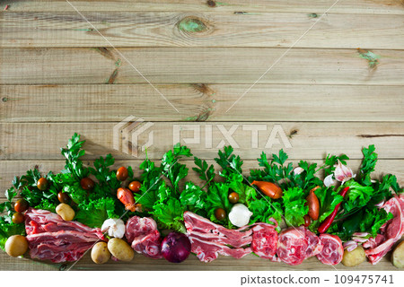 Raw mutton and vegetables assortment on natural wooden background 109475741