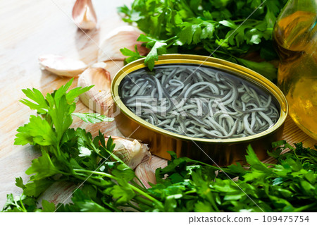 Pickled angoulas in tin can with garlic and parsley. Pickled angoulas in tin can with garlic and parsley. 109475754