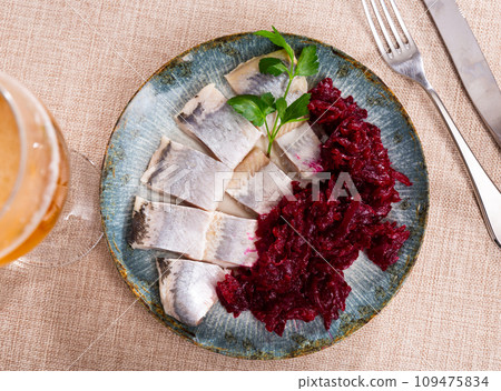Lightly salted herring with beets served on platter 109475834
