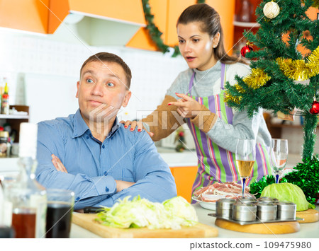 Unhappy woman quarreling with husband during cooking Unhappy woman quarreling with husband during cooking 109475980