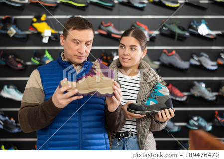 Man with daughter chooses winter trekking cross shoes Man with daughter chooses winter trekking cross shoes 109476470