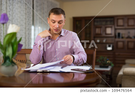 Concentrated man filling out papers Concentrated man filling out papers 109476564