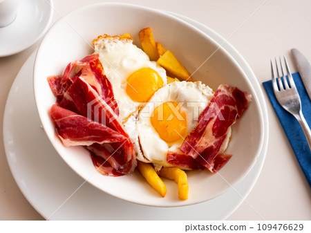 Scrambled eggs with ham and french fries Scrambled eggs with ham and french fries 109476629