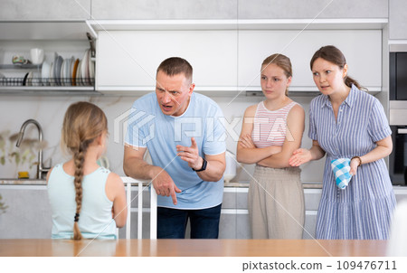 Parents and elder sister scold daughter in kitchen Parents and elder sister scold daughter in kitchen 109476711