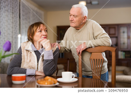 Senior man asking for forgiveness from offended wife 109476950