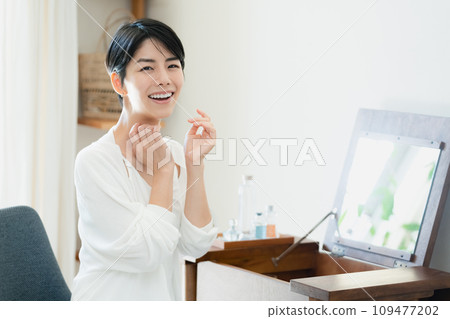 A woman doing skin care in her room 109477202