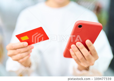 Woman's hand with credit card and smartphone 109477339