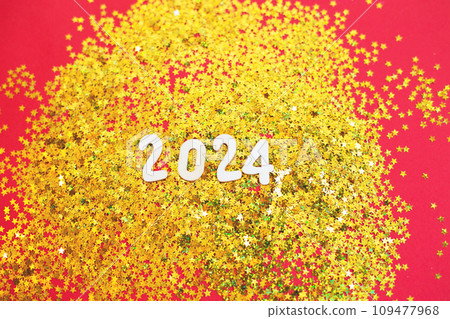 wooden number 2024 on christmas shiny golden background with sparkle festive golden confetti 109477968