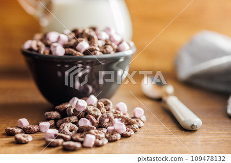 Sweet breakfast cereals in bowl on kitchen table. Sweet breakfast cereals in bowl on kitchen table. 109478132