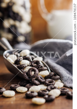 Sweet breakfast cereals in scoop on kitchen table. 109478137