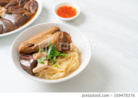 dried noodles with braised duck in white bowl 109478376