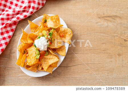 nachos tortilla chips with jalapeno, guacamole, tomatoes salsa and dip 109478389