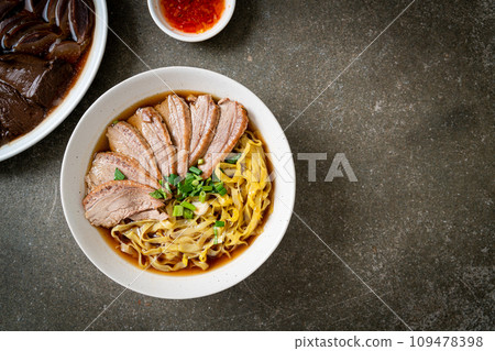 egg noodles with stewed duck in brown soup 109478398