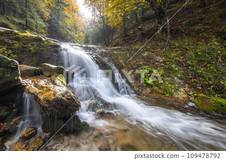 Autumn landscape with waterfall in a beautiful backlight. 109478792