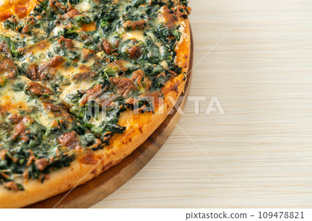 spinach and cheese pizza on wood tray 109478821