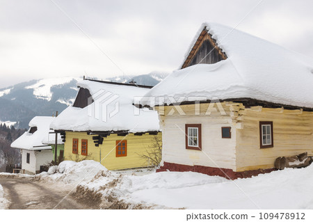 Folk architecture in snowy winter landscape. 109478912