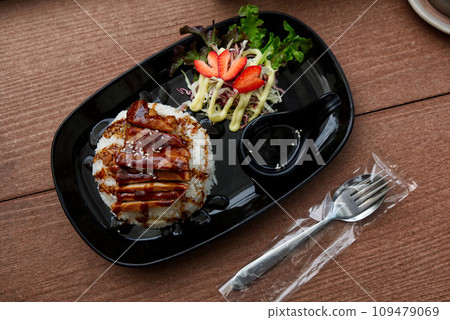 Steamed Jasmine Rice Paired with Fried Pork and Delicious Japanese-Style Dipping Sauce, Served on the Dining Table. 109479069