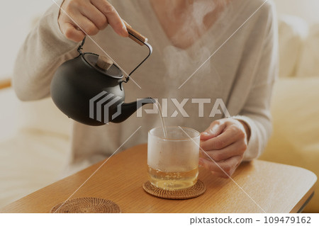 一個女人在茶壺裡泡熱茶 109479162