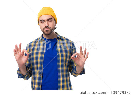 young stylish brunette man with a beard and mustache in a shirt and hat thinks holding his head young stylish brunette man with a beard and mustache in a shirt and hat thinks holding his head 109479382