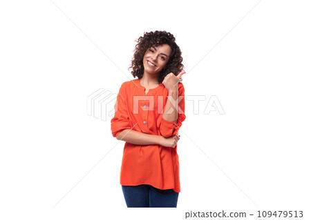 young curly brunette woman dressed in an orange blouse on a white background 109479513