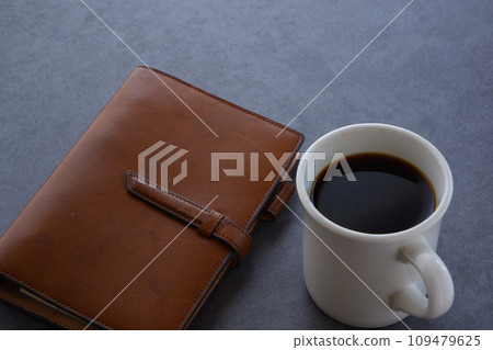 Image of working at a desk with a notebook while drinking coffee 109479625
