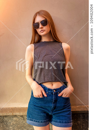 Portrait of Young Woman with Hands in Pockets on Wall Portrait of Young Woman with Hands in Pockets on Wall 109482004