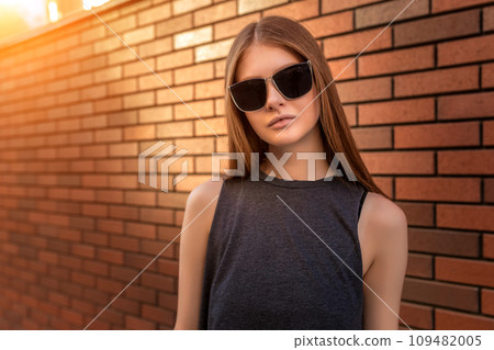 Portrait of Young Woman on Brick Wall Background. Portrait of Young Woman on Brick Wall Background. 109482005