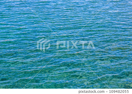 Blue sea in sunshine glow as surface background. Summer holidays concept Blue sea in sunshine glow as surface background. Summer holidays concept 109482055
