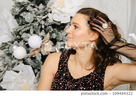 Smiling woman in profile near Christmas tree Smiling woman in profile near Christmas tree 109484322