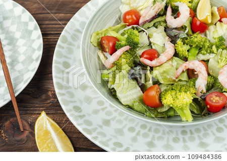 Bowl of salad with broccoli and shrimp. 109484386