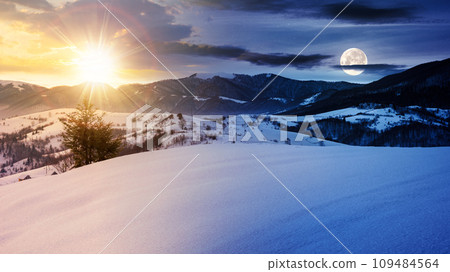 mountainous winter landscape in morning light. solstice scenery with snow covered rolling hills in the distance beneath a sky with sun and moon. day and night time change concept 109484564