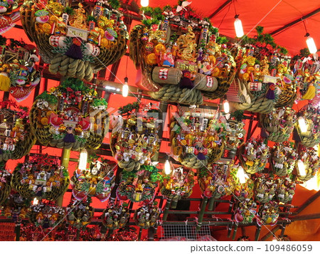 Lucky kumades lined up in rows at the rake shop in Tori no Ichi 109486059