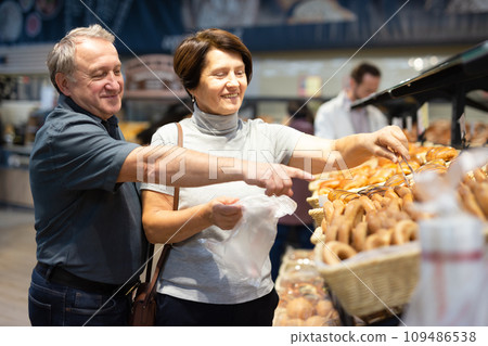 Couple chooses sweet puffs in bakery 109486538