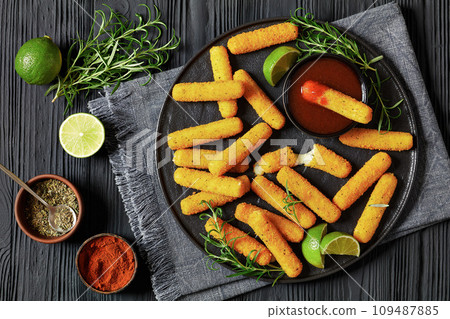 fried mozzarella sticks with sauce on black plate 109487885